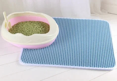 Cat litter box with a blue mat on a tiled floor